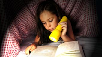 girl reading in bed flashlight
